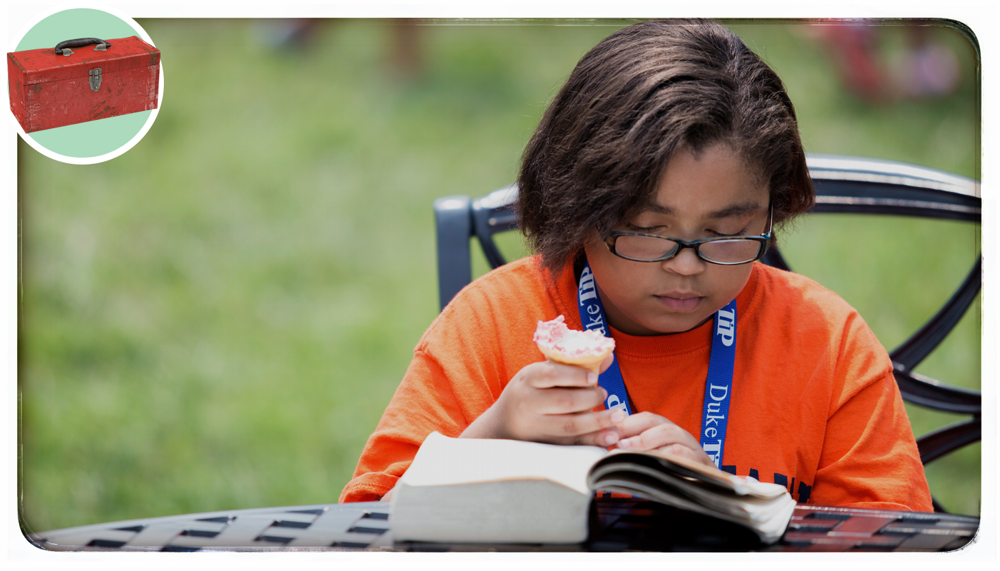 A girl reading a book outside with an ice cream cone in her hands